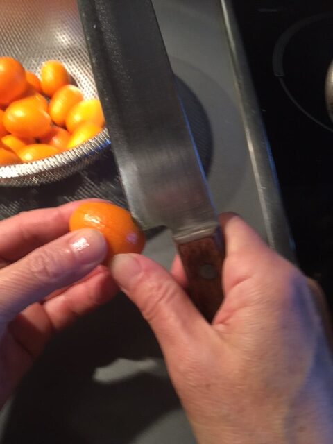 Kumquats werden mit dem Messer eingeschnitten