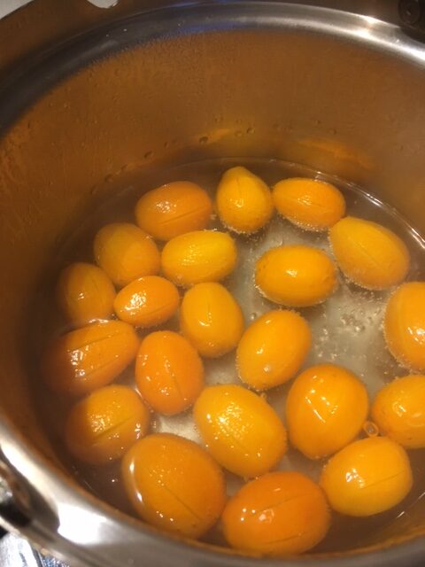 Kumquats köcheln in Wasser