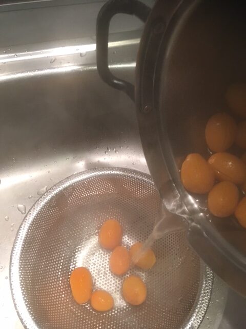 Kumquats werden in ein Sieb abgegossen